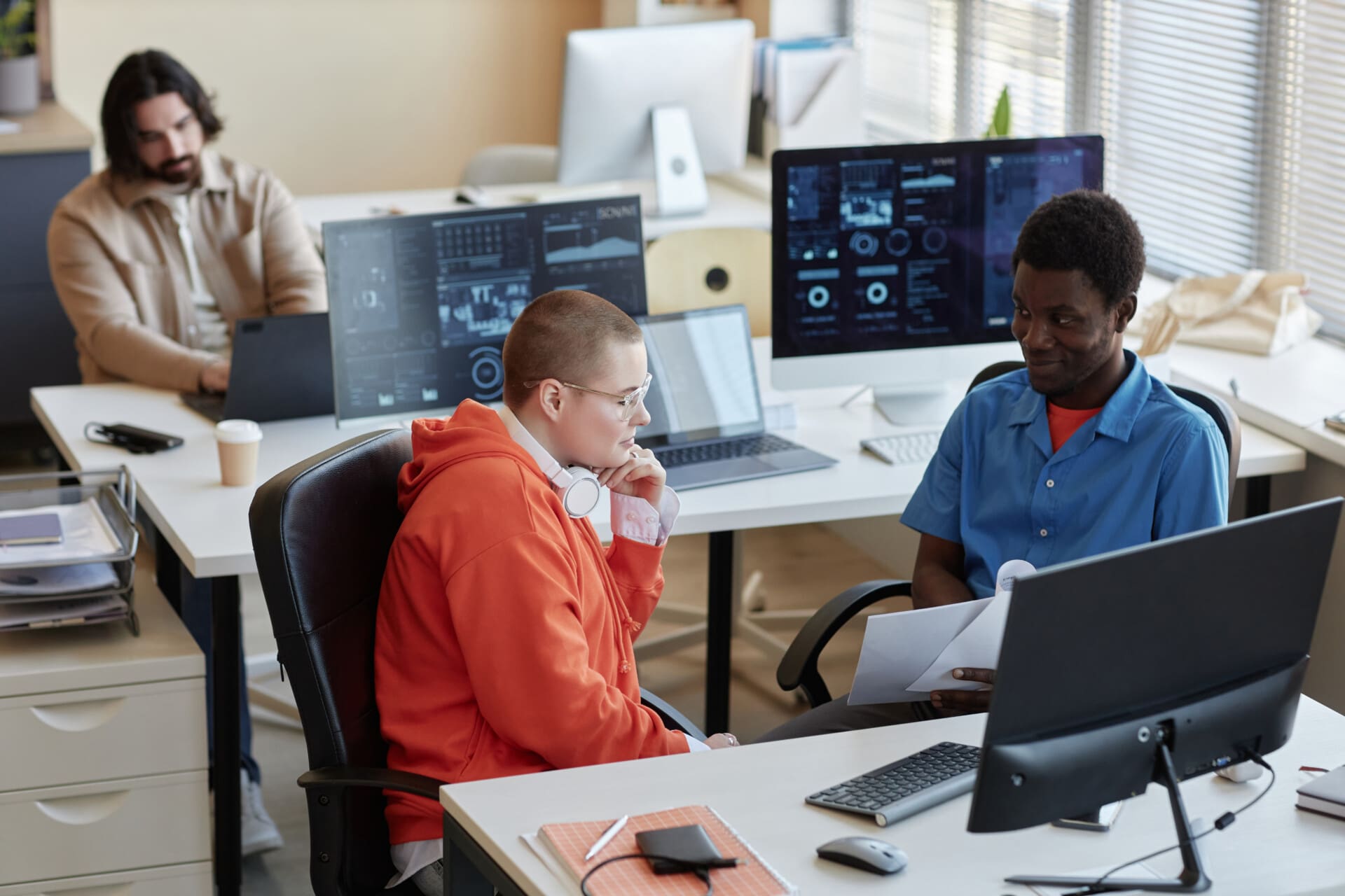 Young African American male manager with papers making report to colleague