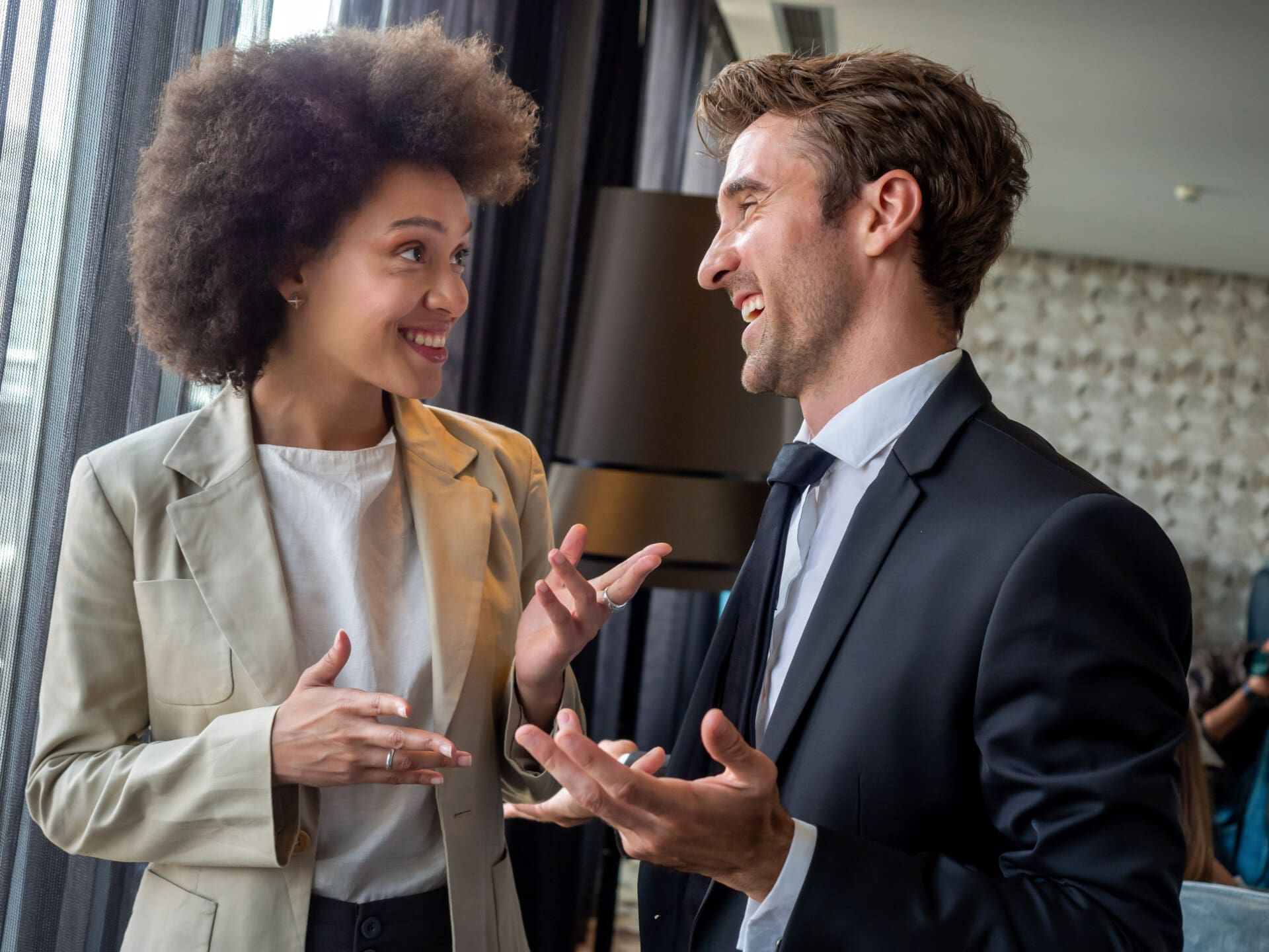 Happy business colleagues talking in modern office