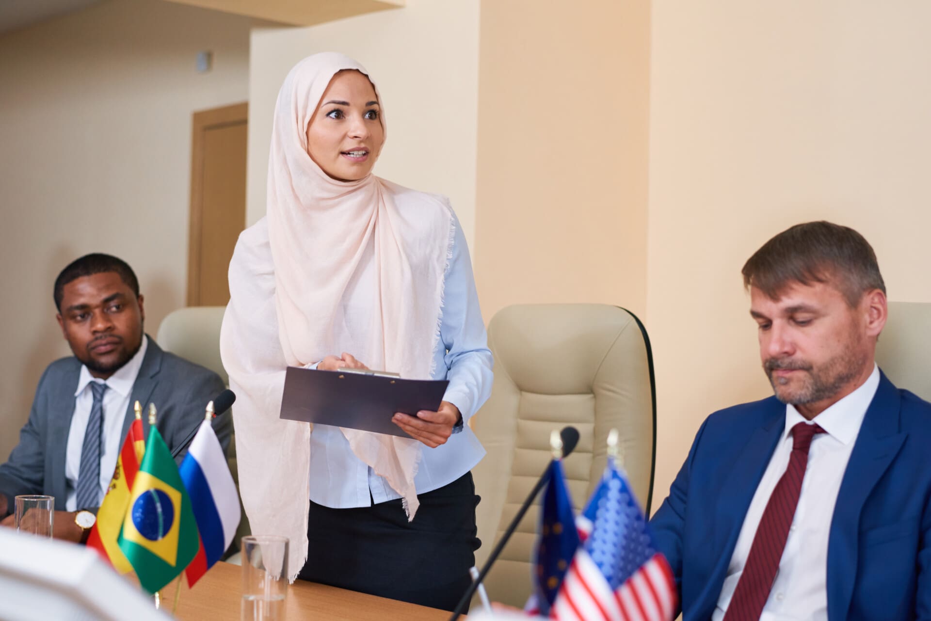 Young muslim female in hijab making report at conference
